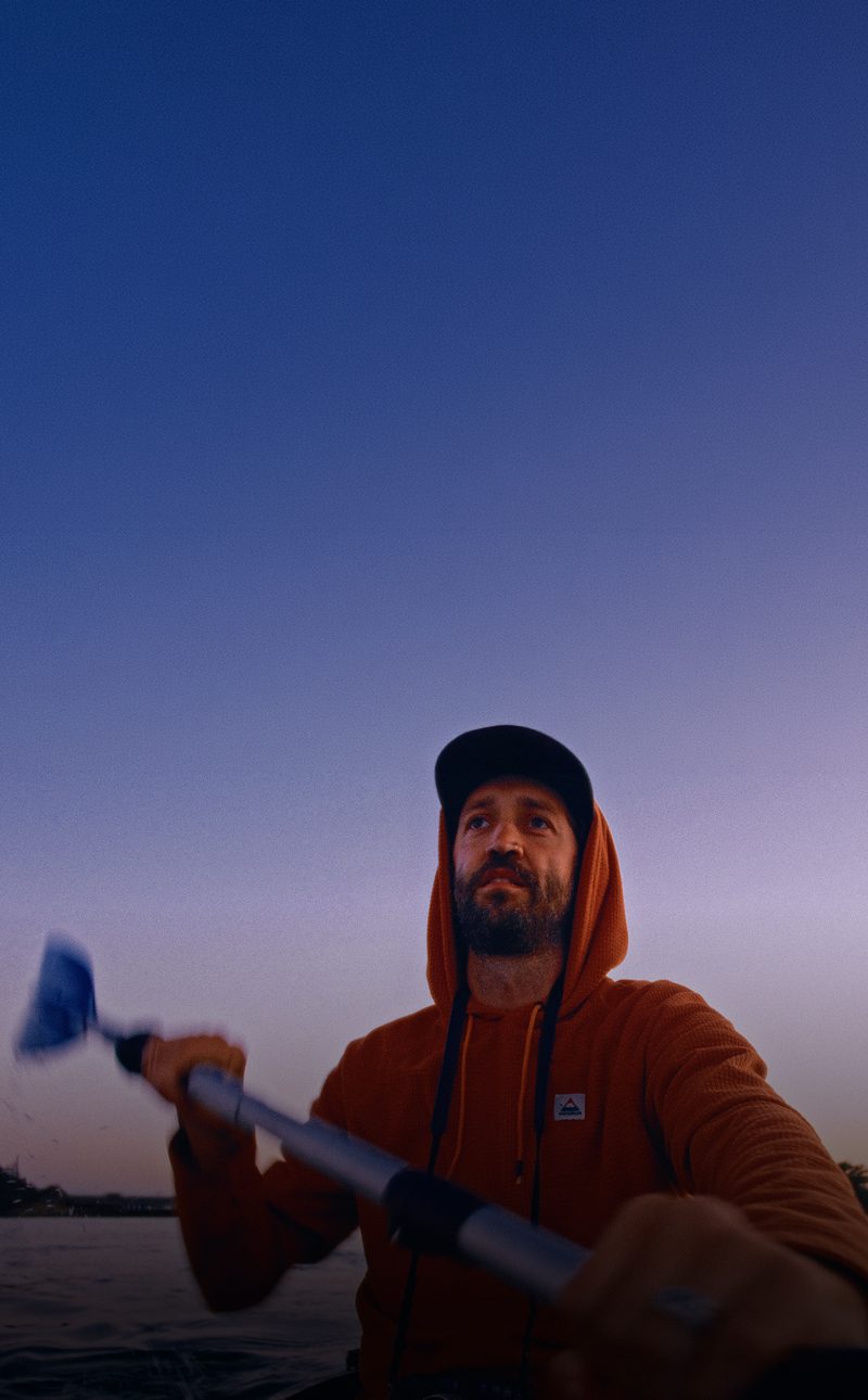 Kyson paddling a kayak at dusk